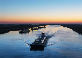 Dusk shot of barges traversing a short canal that connects the Sabine Pass waterway separating Texas from Louisians, and the Trinity River, south of Port Arthur, Texas., Carol Highsmith - plakat 29,7 - Galeria Plakatu
