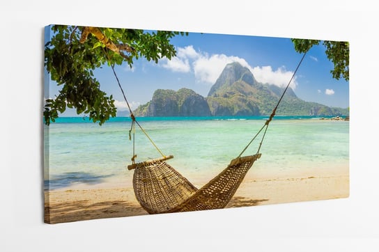 Obraz na płótnie HOMEPRINT, tradycyjny pleciony hamak w cieniu na tropikalnej wyspie, wyspa, plaża, palmy, wakacje 120x50 cm HOMEPRINT
