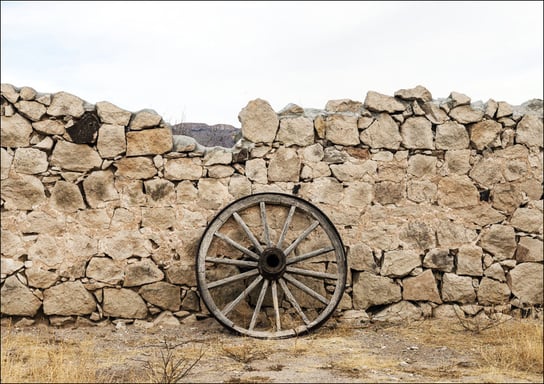 Wagon wheel against a stone fence at Hueco Tanks State Park, northwest of El Paso, USA, Carol Highsmith - plakat 100x70 cm Galeria Plakatu